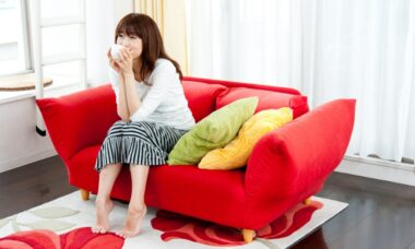 ソファーで飲み物を飲む女性